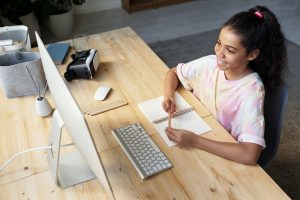 Girl studying at a desk with a computer