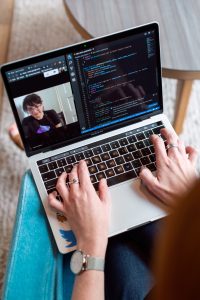 Person typing on a laptop during a video call