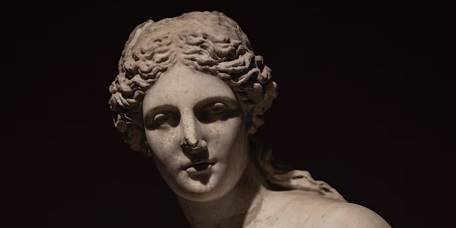 Marble sculpture of a woman's head against a dark background