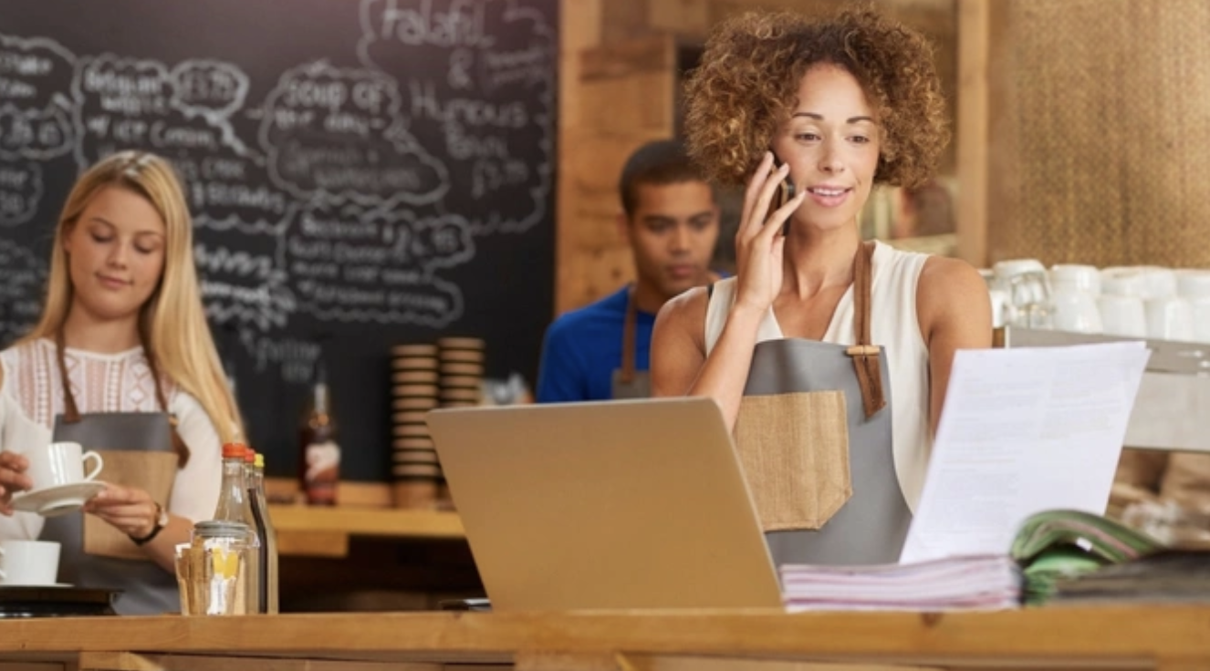 Women working at a cafe counter with a laptop