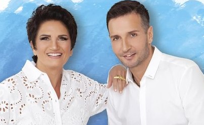 Smiling couple in white against a blue background