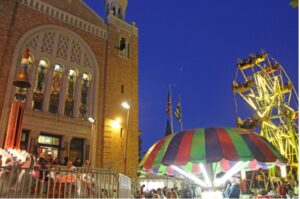 Crowd at a Greek festival with a carousel outside a church at night